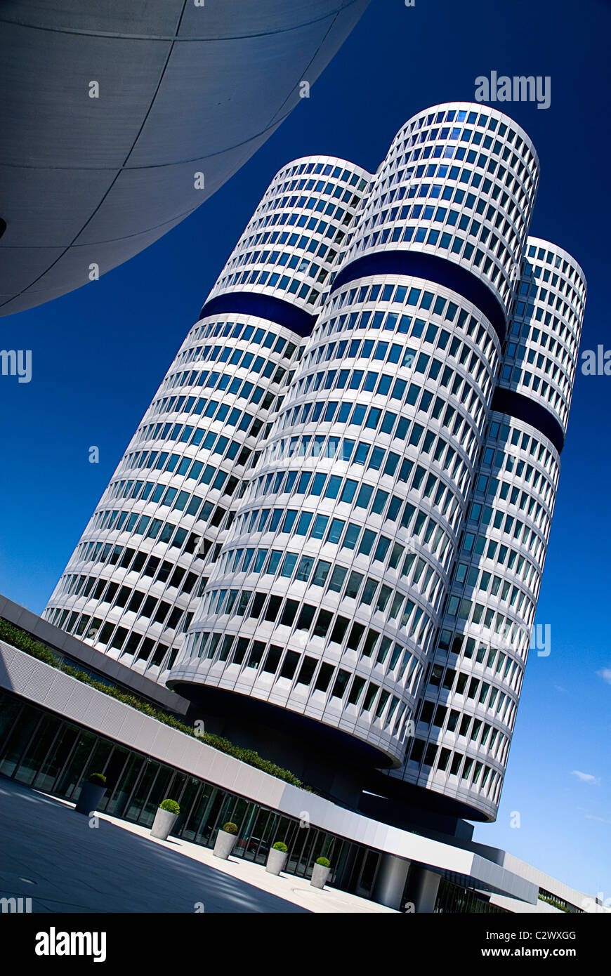 In Germania, in Baviera, Monaco di Baviera, sede della BMW, la BMW Tower è 101 metri di altezza ed imita la forma di pneumatici. Foto Stock