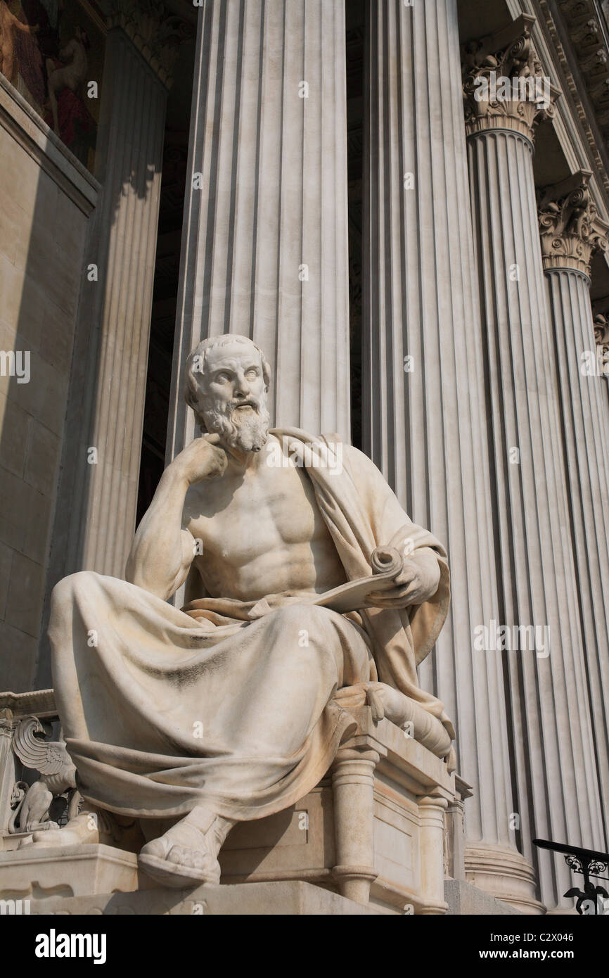 Austria, Vienna, seduto statua del filosofo greco Erodoto nella parte anteriore delle colonne del palazzo del Parlamento. Foto Stock