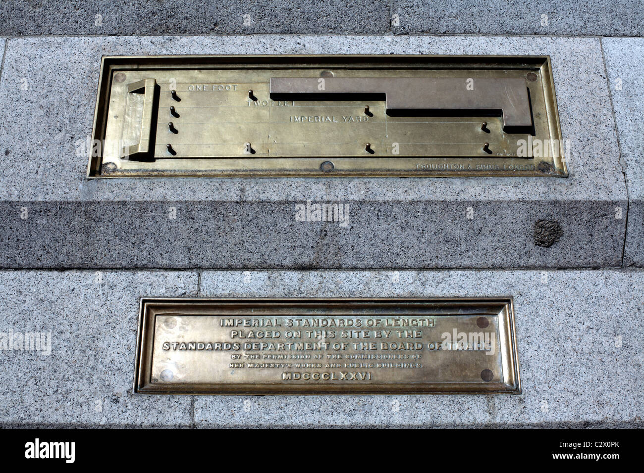 Segni di metallo, datata 1876, specificando imperial standard di lunghezza (piedi e cantiere) inglobati nella pavimentazione in Trafalgar Square. Foto Stock