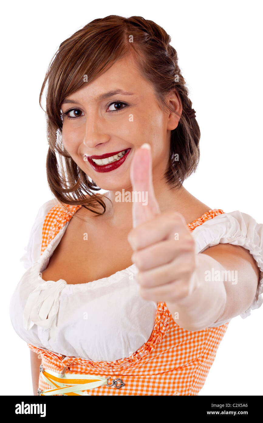 Junge hübsche, Bayerische Frau im Dirndl zeigt Daumen nach oben. Isoliert auf weißem Hintergrund. Foto Stock