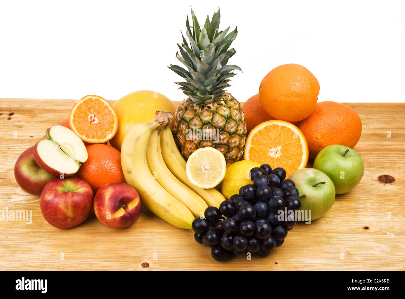 Varietà freschi frutti di tutte le stagioni su una tavola di legno isolato su sfondo bianco Foto Stock