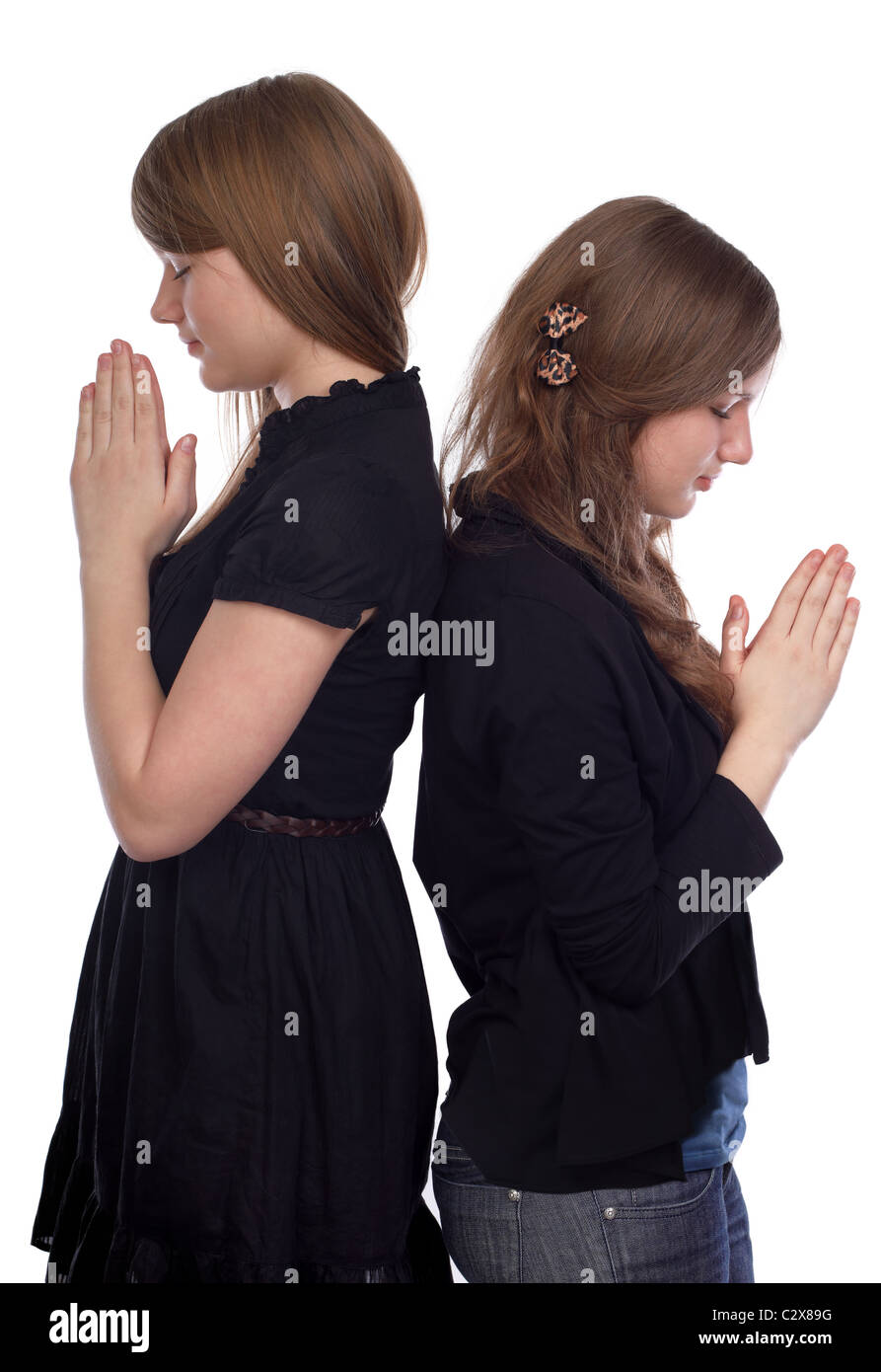 Due ragazze in piedi di schiena al momento di preghiera Foto Stock