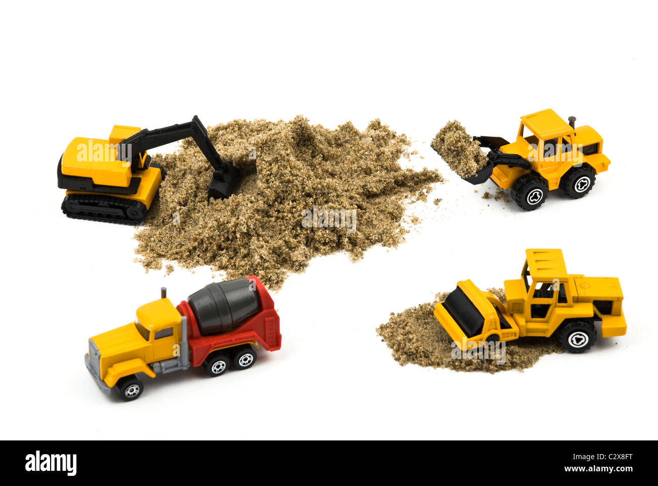 Carrelli di lavoro in miniatura con sabbia isolata su sfondo bianco Foto Stock
