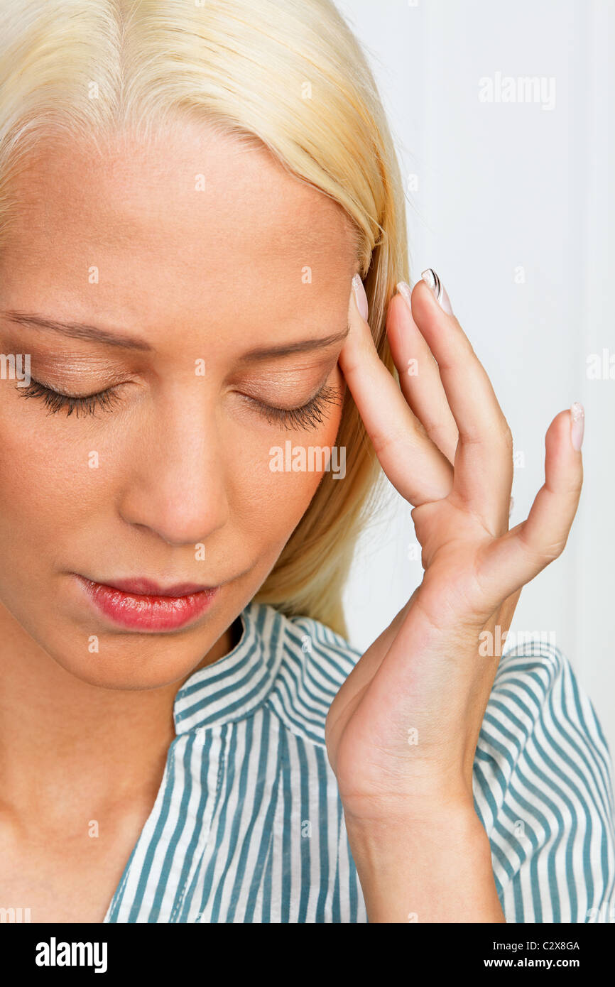Giovane donna cercando di curare il mal di testa Foto Stock