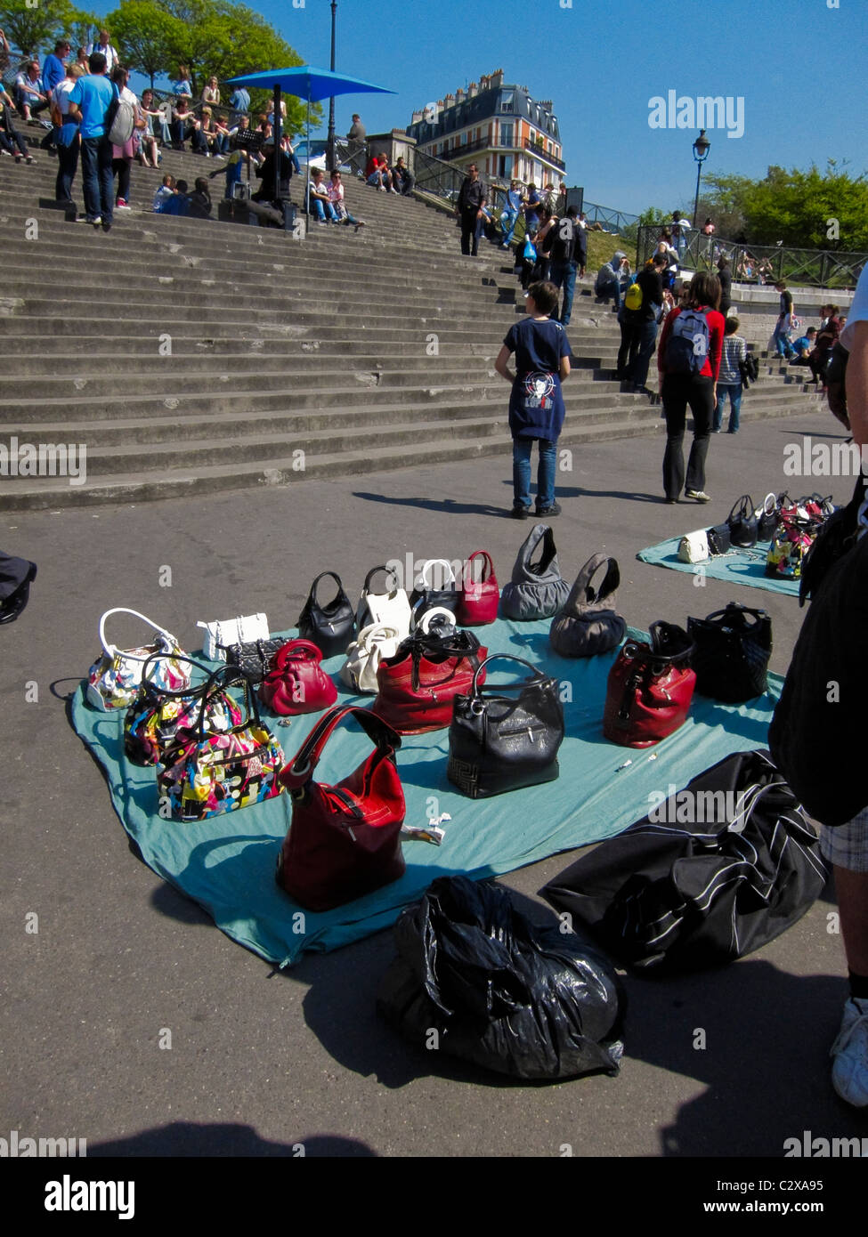 Parigi, Francia, gente, Collezione, turisti Shopping nelle bancarelle turistiche del quartiere Butte Montmartre, uomo africano che vende borse contraffatte su gradini, via Parigi di giorno Foto Stock