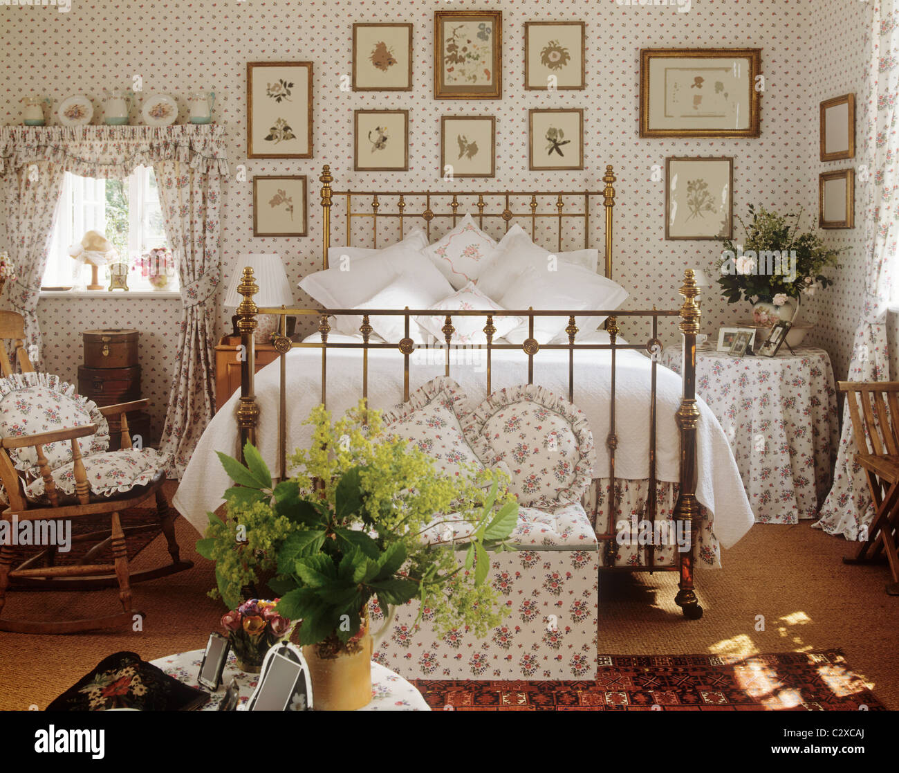 Il ferro battuto e letto in ottone in graziosa camera da letto floreale Foto Stock