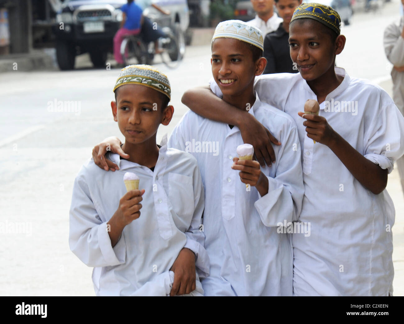 Ragazzi musulmani a mangiare il gelato sulla loro strada per la scuola musulmana, Mae Sot , ovest della Thailandia Foto Stock