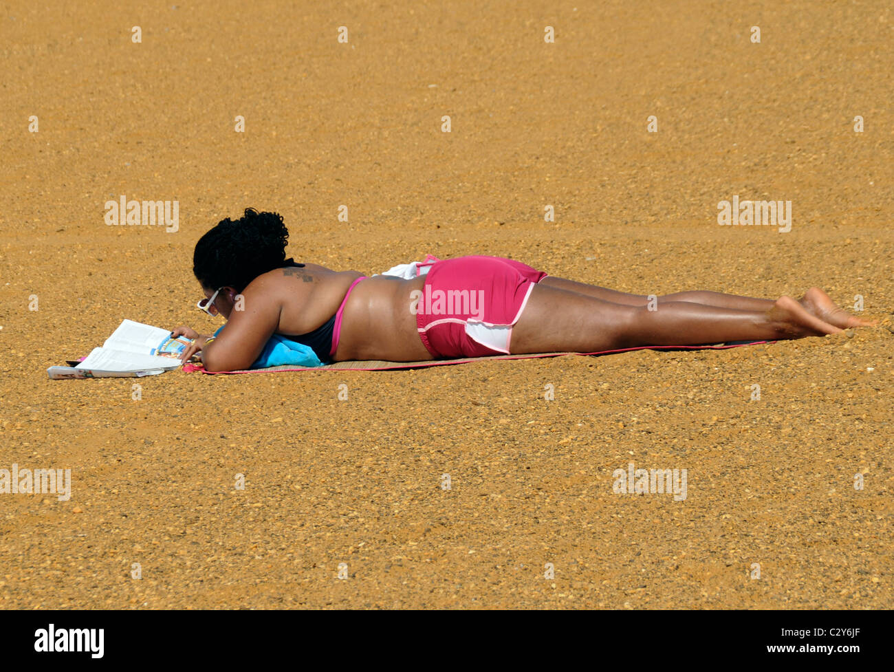 La donna si rilassa leggendo sulla spiaggia sabbiosa spiaggia di punto in punto di sabbia, Maryland Foto Stock