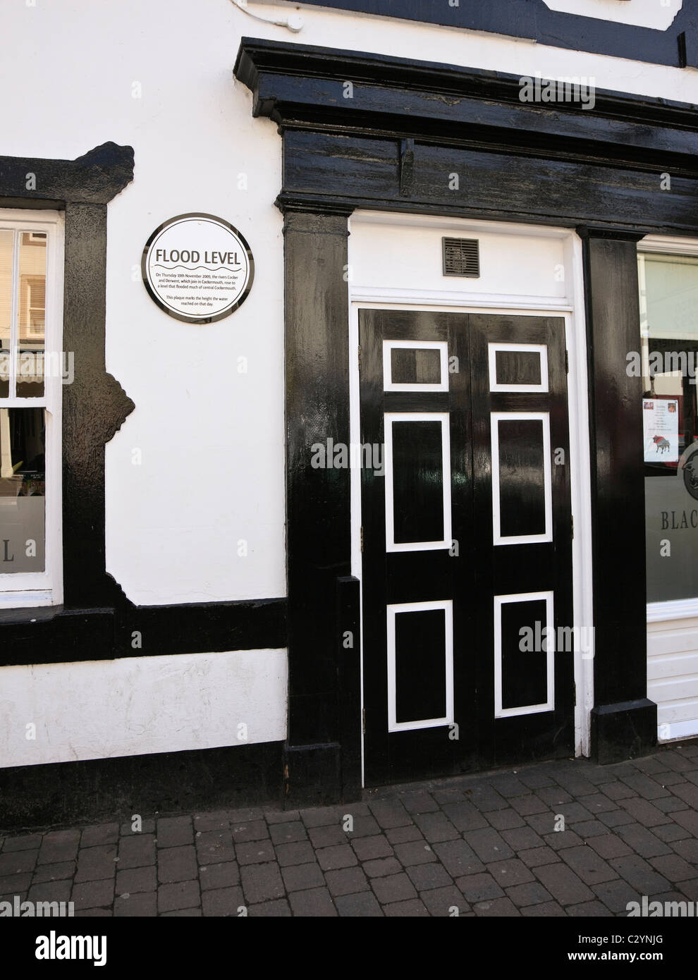 La placca che mostra 2009 flood'altezza di livello di acqua dalla porta di Black Bull pub nel centro della città. Main St Cockermouth Cumbria Inghilterra England Regno Unito Foto Stock