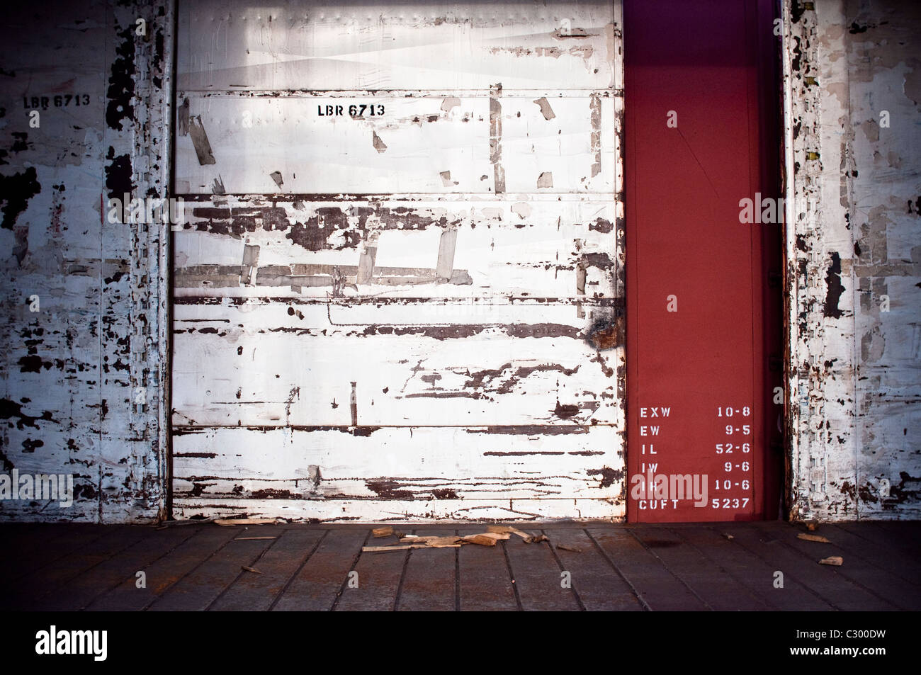 L'interno di un vuoto abbandonato treno merci trasporto in Pennsylvania, Stati Uniti d'America. Le porte di carico sono aperti rivelando numero di codici. Foto Stock