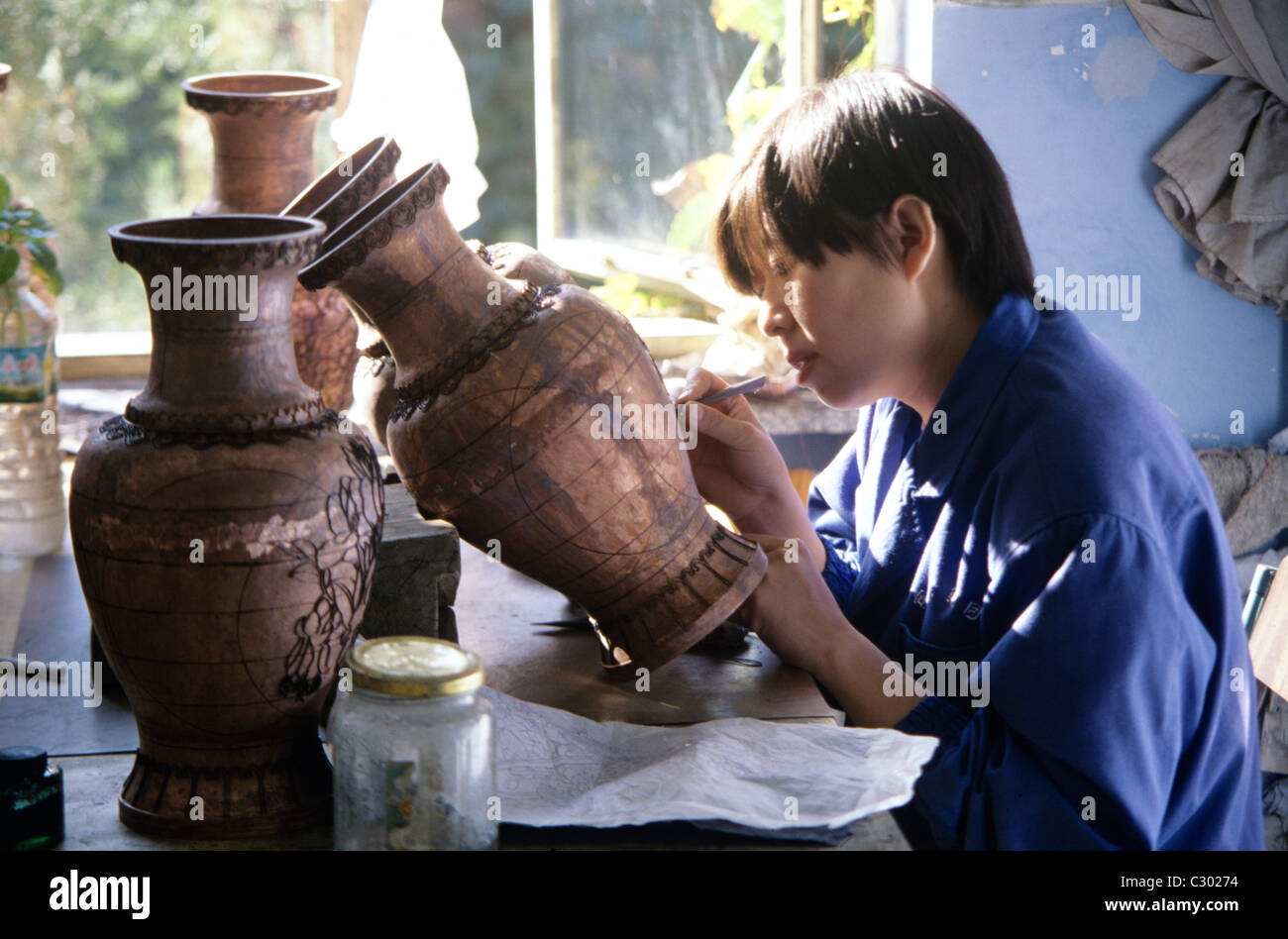 Suzhou, Cina. Artigiano scolpisce disegni sul famoso red terraglie di argilla in fabbrica e visitato da visite guidate. © Bob Kreisel Foto Stock