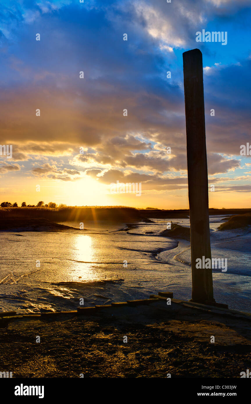 Caldo arancio tramonto a Brancaster Staithe, Norfolk Foto Stock