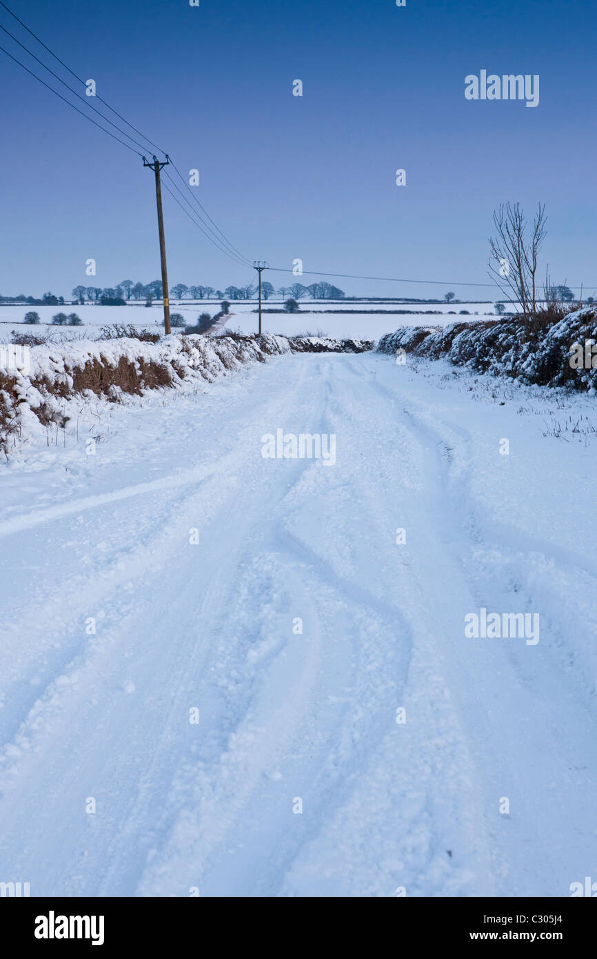 Vicolo del paese nella neve profonda in Cotswolds, Swinbrook, Oxfordshire, Regno Unito Foto Stock