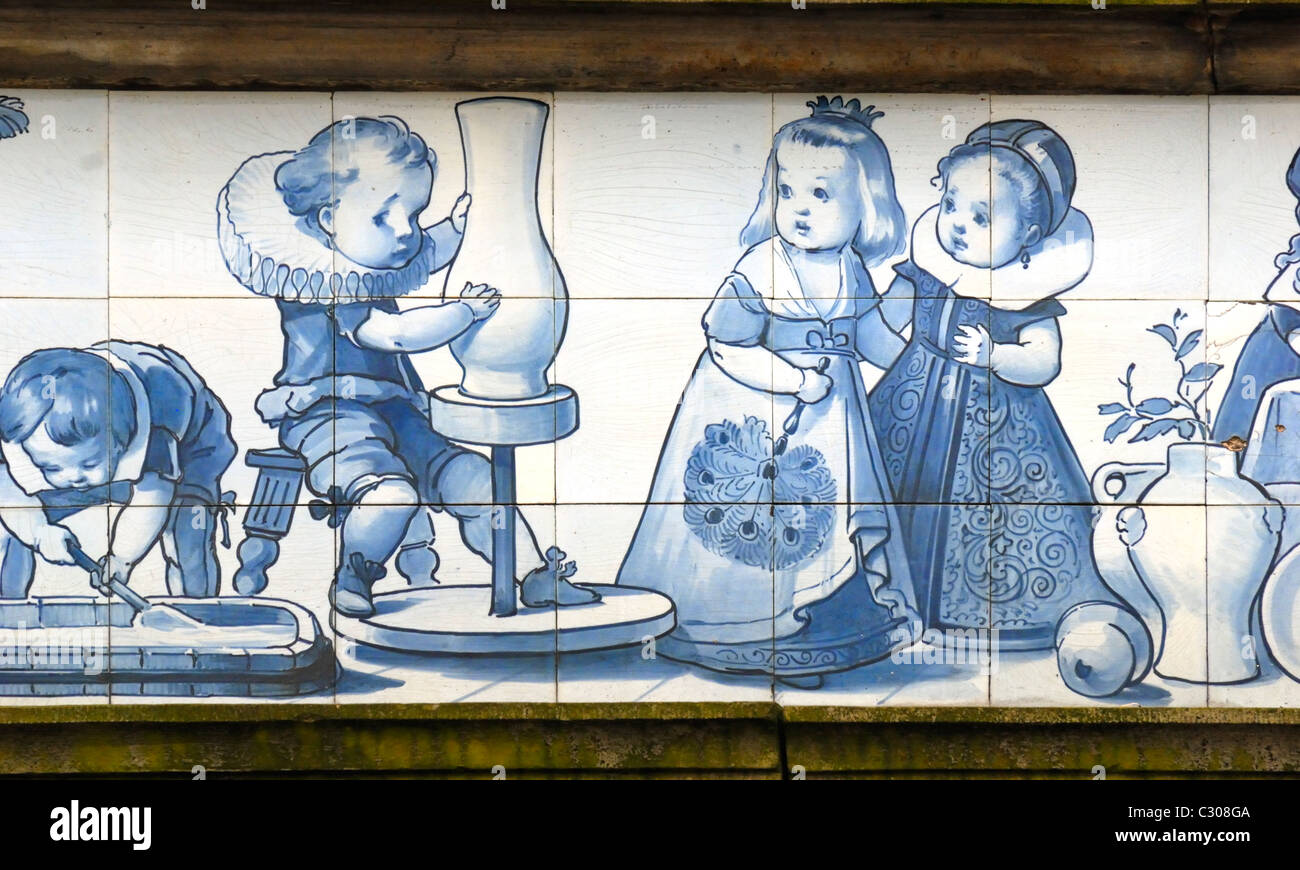 Delft, Paesi Bassi. Bianco e blu Delft piastrelle ceramiche sopra shopfront in Markt (piazza principale) giovane ragazzo usando un tornio del vasaio Foto Stock