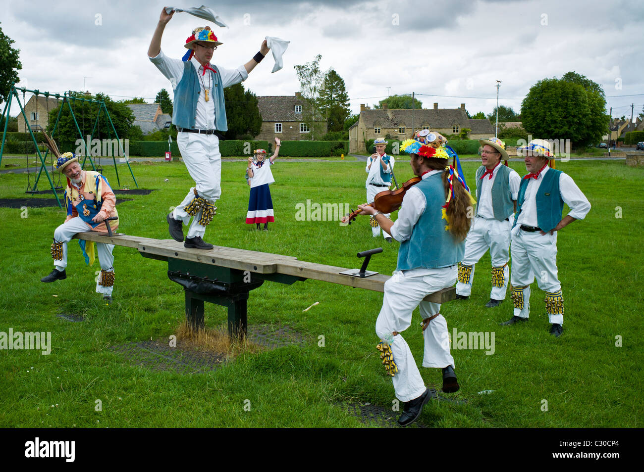 Morris ballerini, Icknield modo Morris uomini, nel parco giochi per bambini presso il kings Head Pub, Bledington, Oxfordshire, Regno Unito Foto Stock