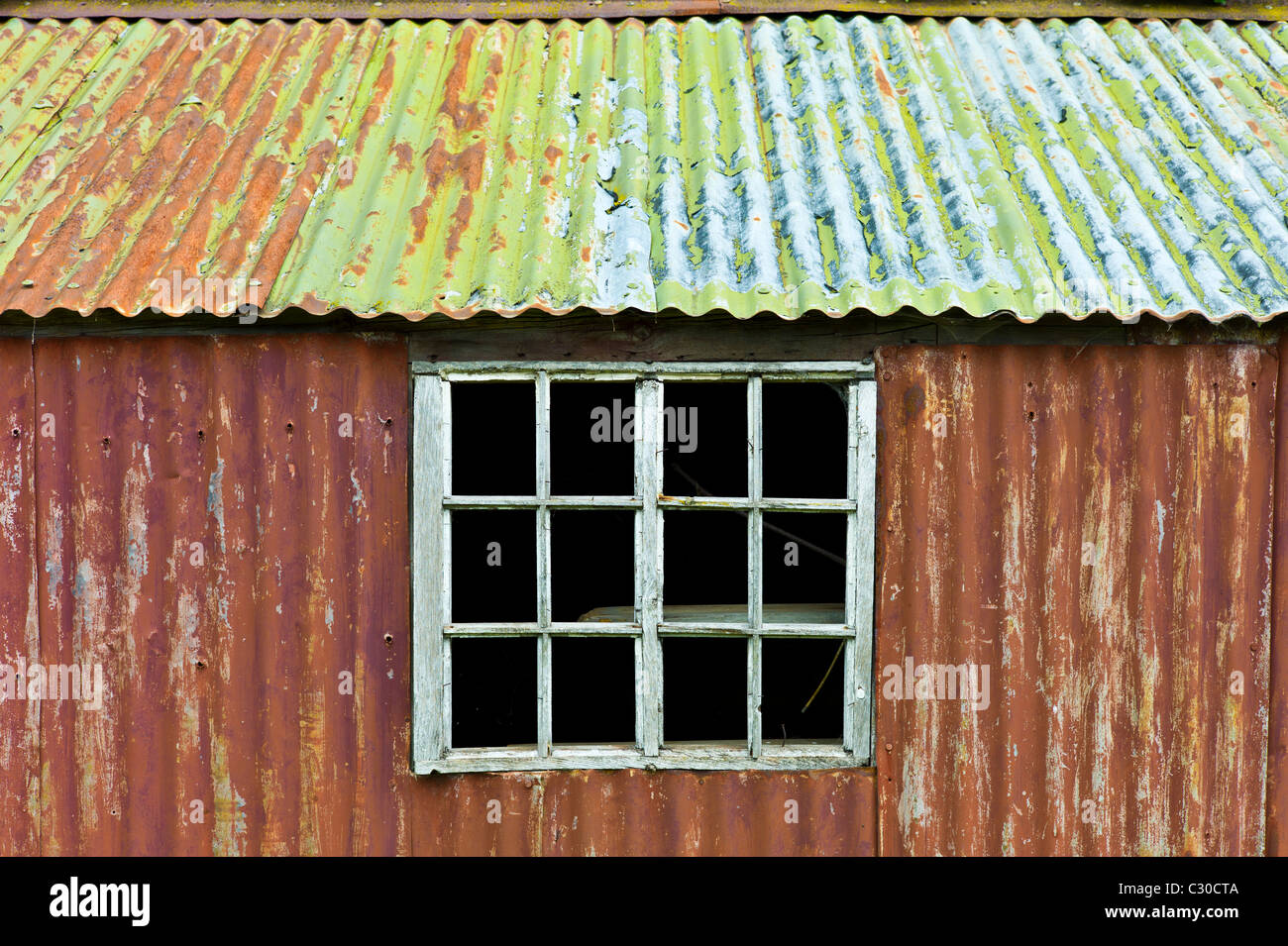 Rusty ferro corrugato sparso in Cotswolds village di Bledington, Oxfordshire, Regno Unito Foto Stock