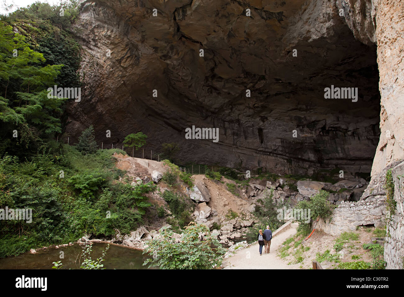 Persone che camminano in entrata del Mas d'Azil dove una strada passa attraverso una grotta Ariège Francia Foto Stock