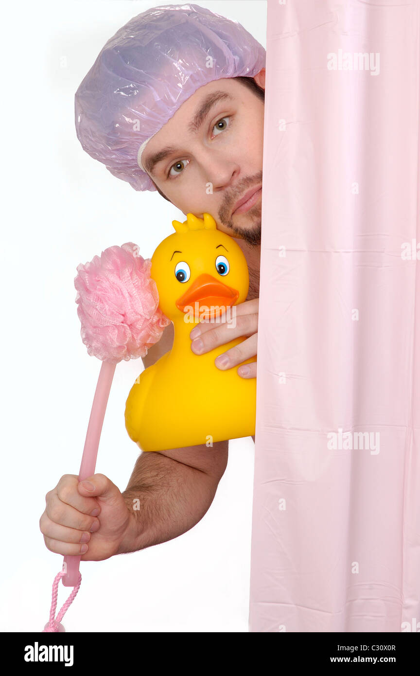 L uomo nella doccia con grande duckie in gomma e retro scrubber. Foto Stock