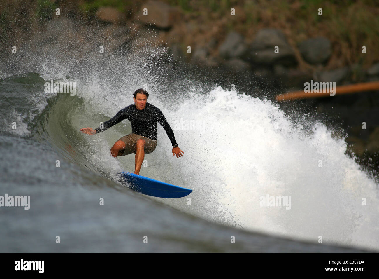 Viaggiare surfer navigando in un'onda a Playa Las Flores, El Salvador Foto Stock