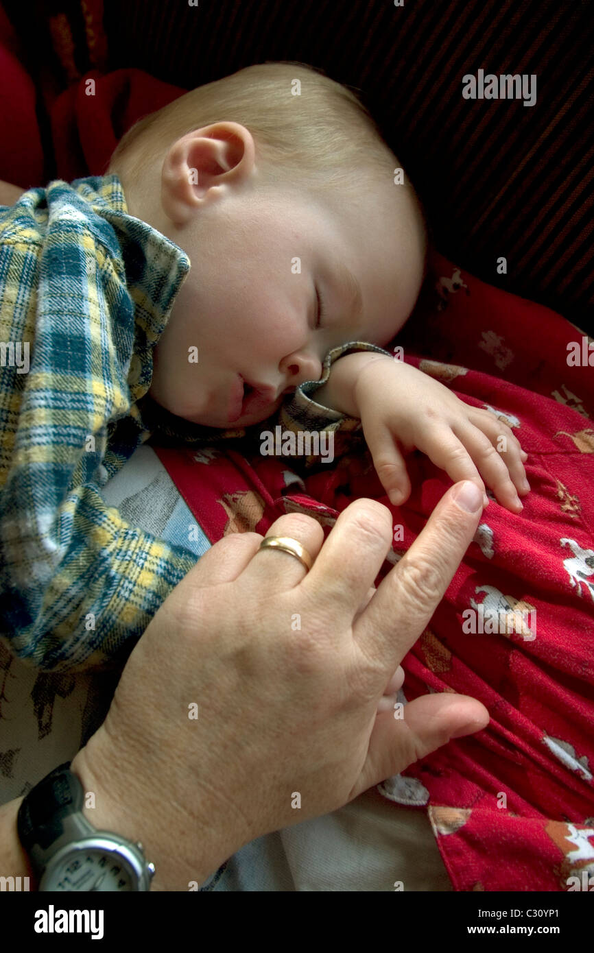 1 anno di età Baby Boy prendendo un pisolino sul lettino. Foto Stock
