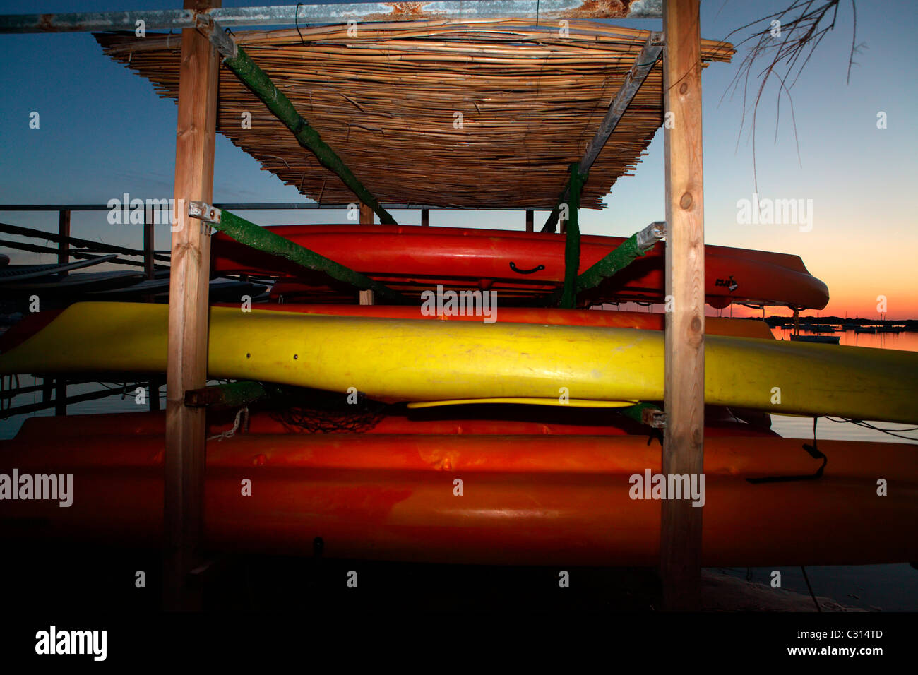 Canoe colorate rimangono parcheggiate nel 'Estany di Peix' in Formentera, un'isola del mediterraneo della Spagna. Foto Stock