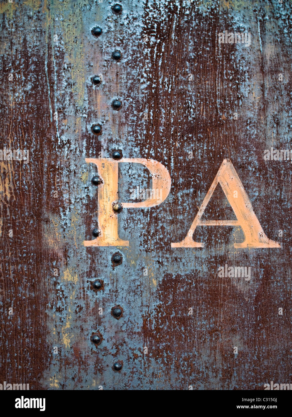 La formazione di ruggine lato di un vecchio treno merci auto, con le lettere in grassetto "PA". La vettura presenta ruggine graffi e texture. Foto Stock