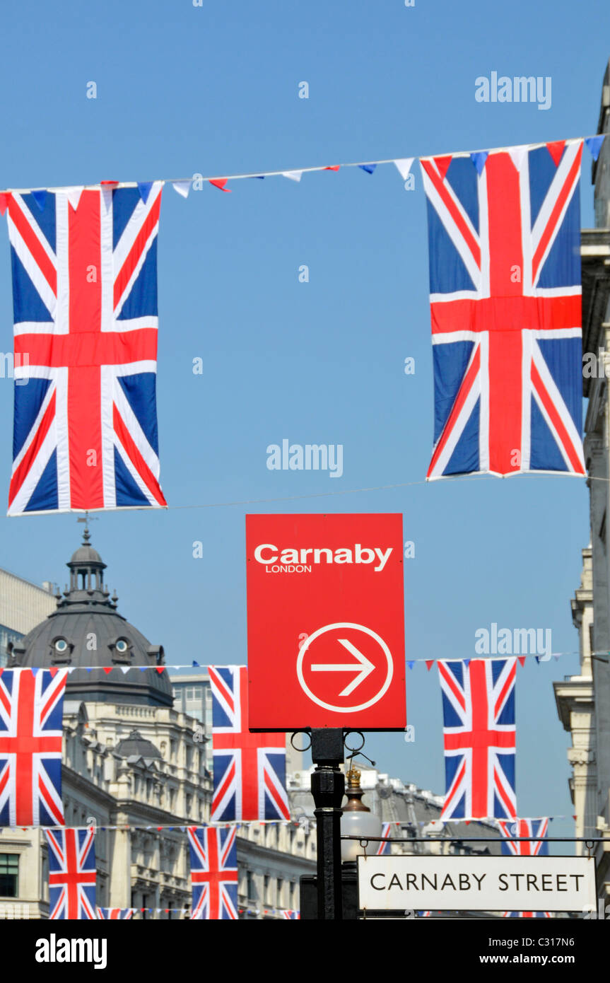 Carnaby Street shoppers sign in London West End e Union Jack bandiere blu cielo giorno Regent Street West End di Londra Inghilterra REGNO UNITO Foto Stock