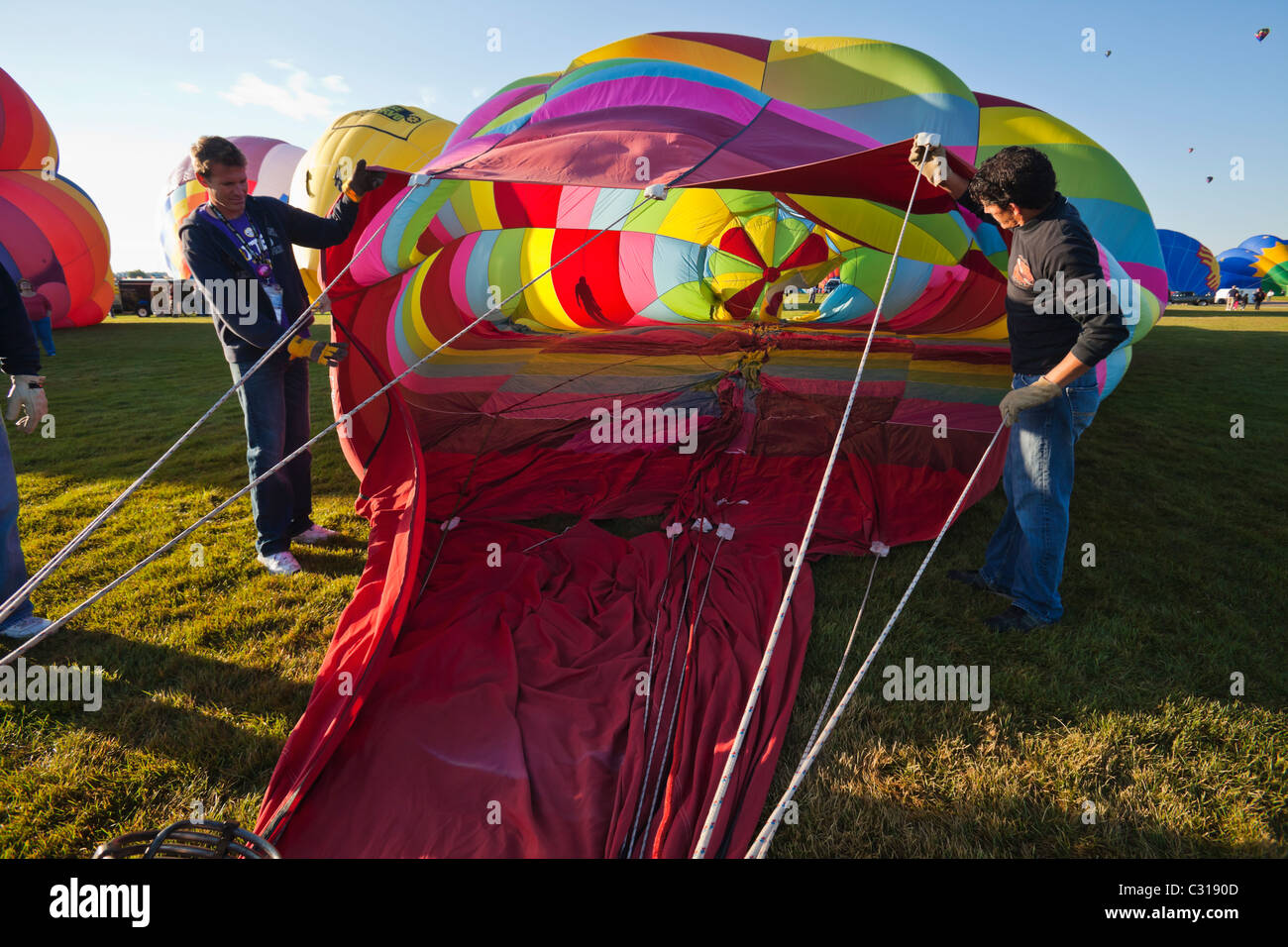 Due uomini che tengono il palloncino aperta come si riempie di aria. Albuquerque, Nuovo Messico, Stati Uniti d'America. Foto Stock