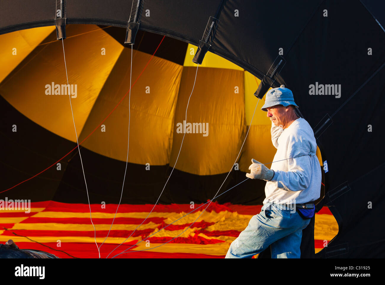 Un uomo che tiene il pallone aprire come si riempie di aria. Albuquerque, Nuovo Messico, Stati Uniti d'America. Foto Stock