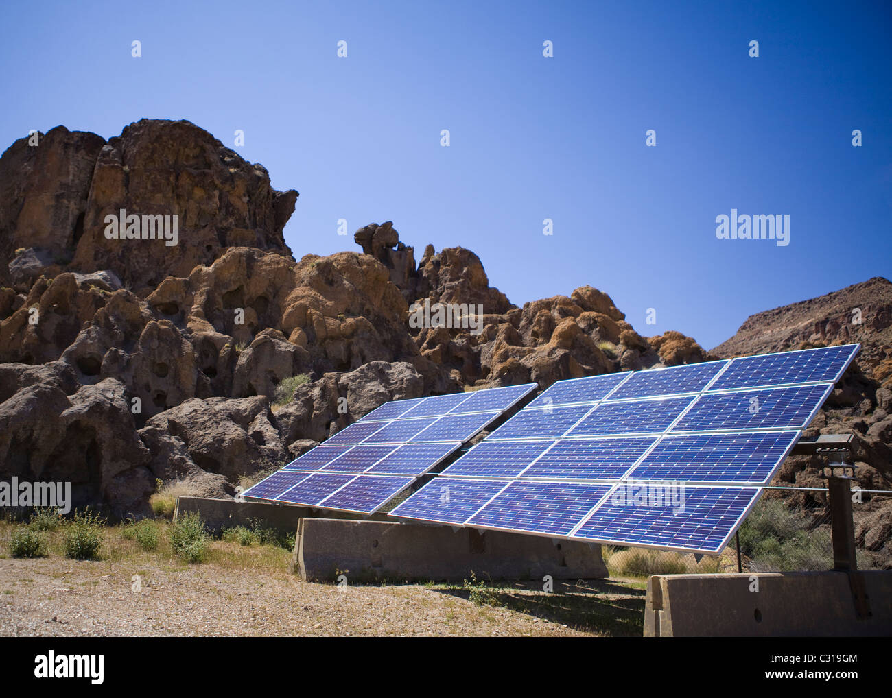 Pannello solare contro il paesaggio roccioso e cielo blu - California USA Foto Stock