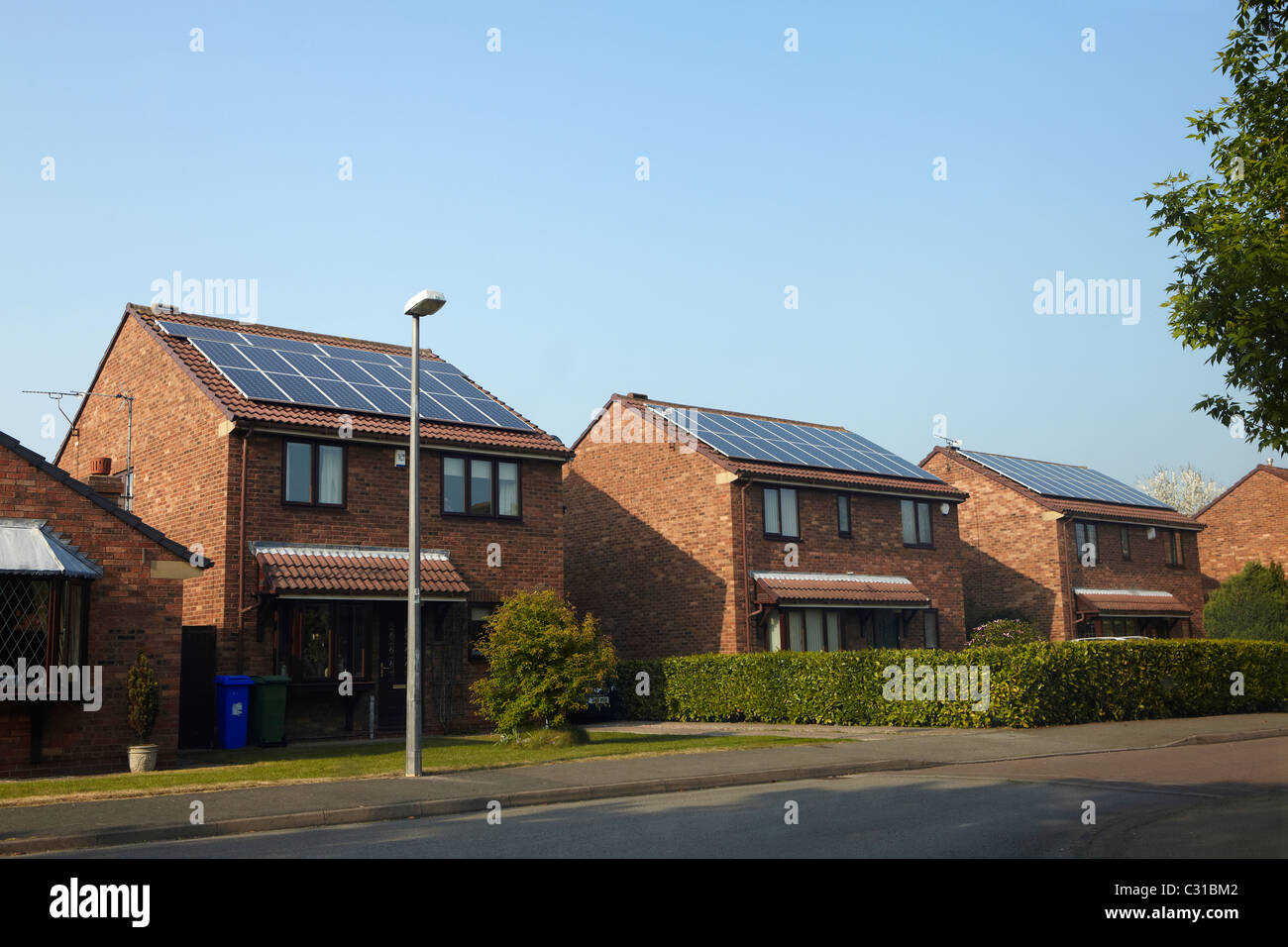 Pannelli solari fotovoltaico PV sulle case in una strada Foto Stock