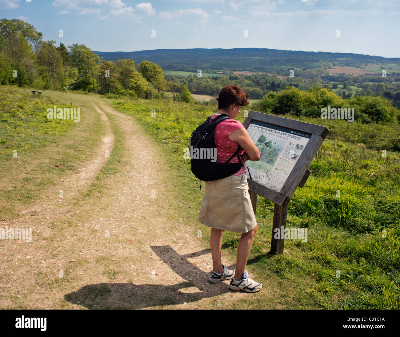 Donna che guarda il Blatchford Downs information board. Foto Stock