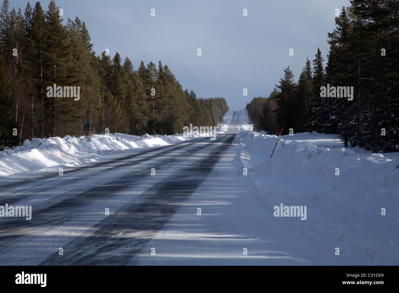 Coperta di neve su strada; Route 95 taglia attraverso le foreste del nord della Svezia Foto Stock