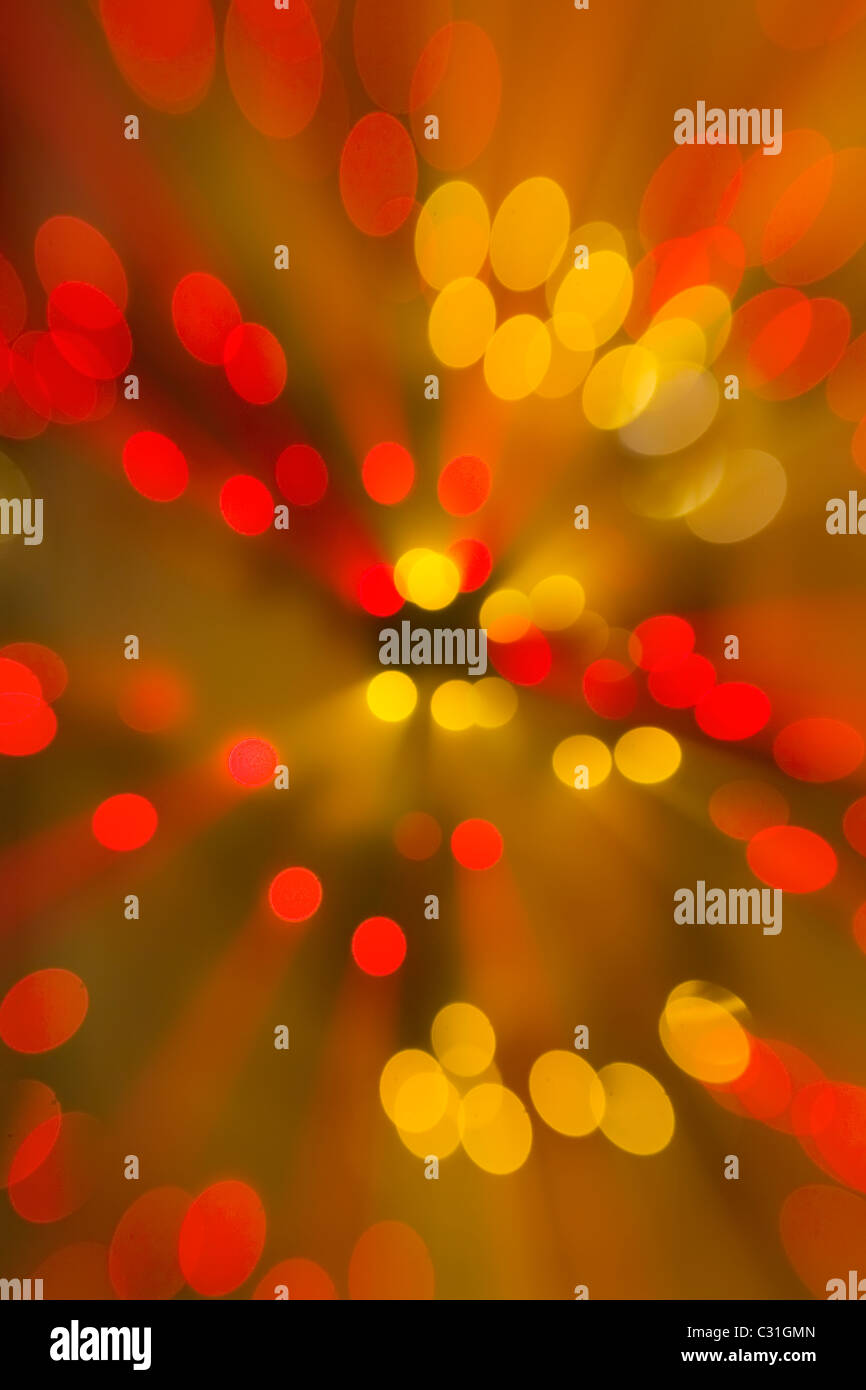 Abstract di colorati di rosso e oro cerchi con i raggi di luce irradia dal centro Foto Stock