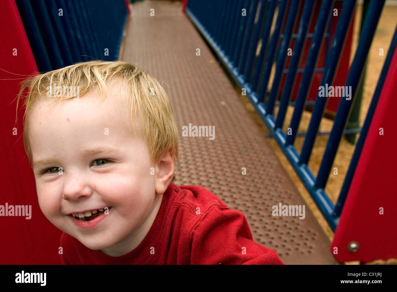 Un bambino felice a suonare in un parco giochi in Alameda, CA Foto Stock