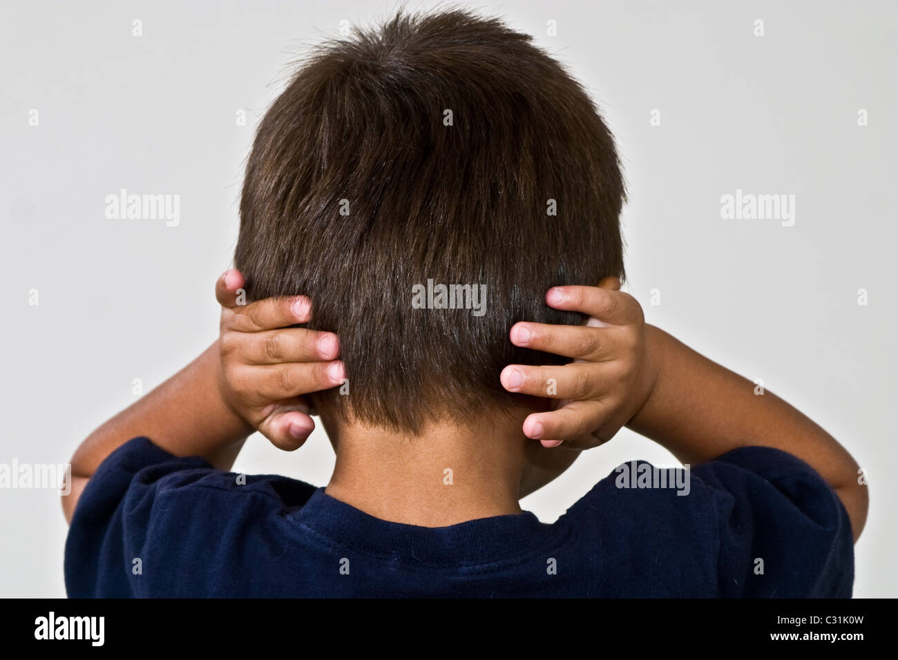 Forte voluta testardo 4-5 anni vecchio ragazzo ispanico che copre le orecchie con le mani. Signor © Myrleen Pearson Foto Stock