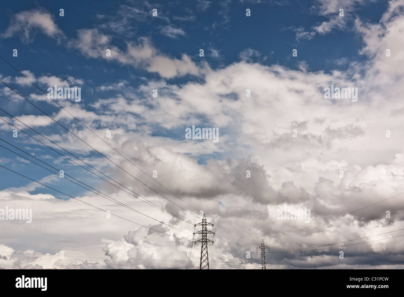 Tensione alta torre contro il cielo blu e nuvole Foto Stock