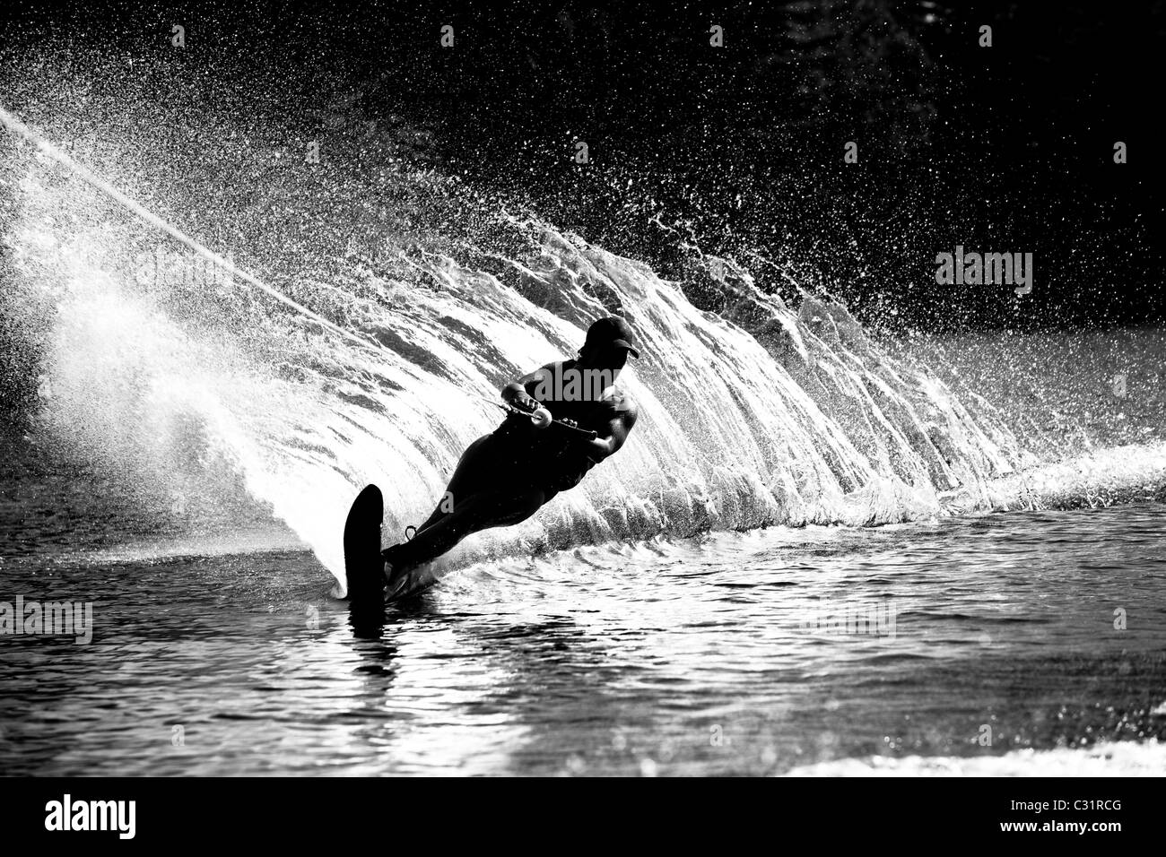 Una femmina di acqua sciatore esegue il rip a sua volta causa un enorme spruzzo di acqua durante la pratica dello sci sul lago Cobbosseecontee vicino Monmouth, Maine. Foto Stock