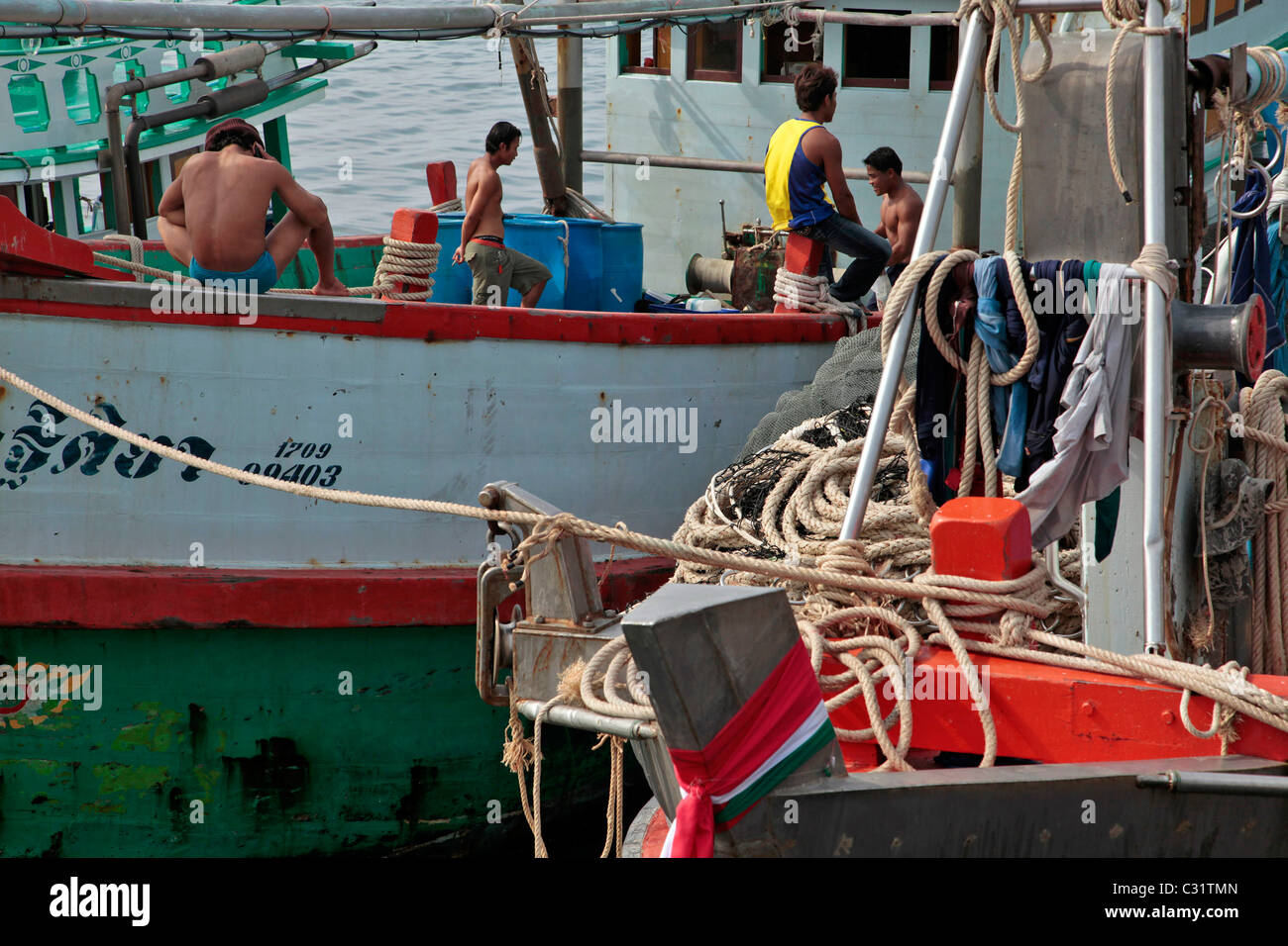 I pescatori birmani sulla loro barca, birmano la manodopera è più conveniente, PORTO DI PESCA DI BANG SAPHAN, Thailandia, ASIA Foto Stock