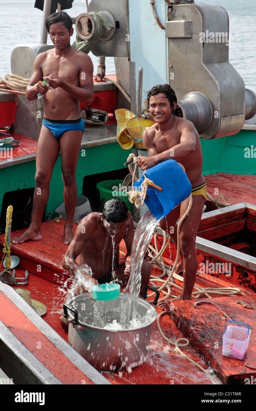 Birmano lavaggio dei pescatori stessi sulla loro barca, birmano la manodopera è più conveniente, PORTO DI PESCA DI BANG SAPHAN, Thailandia, ASIA Foto Stock