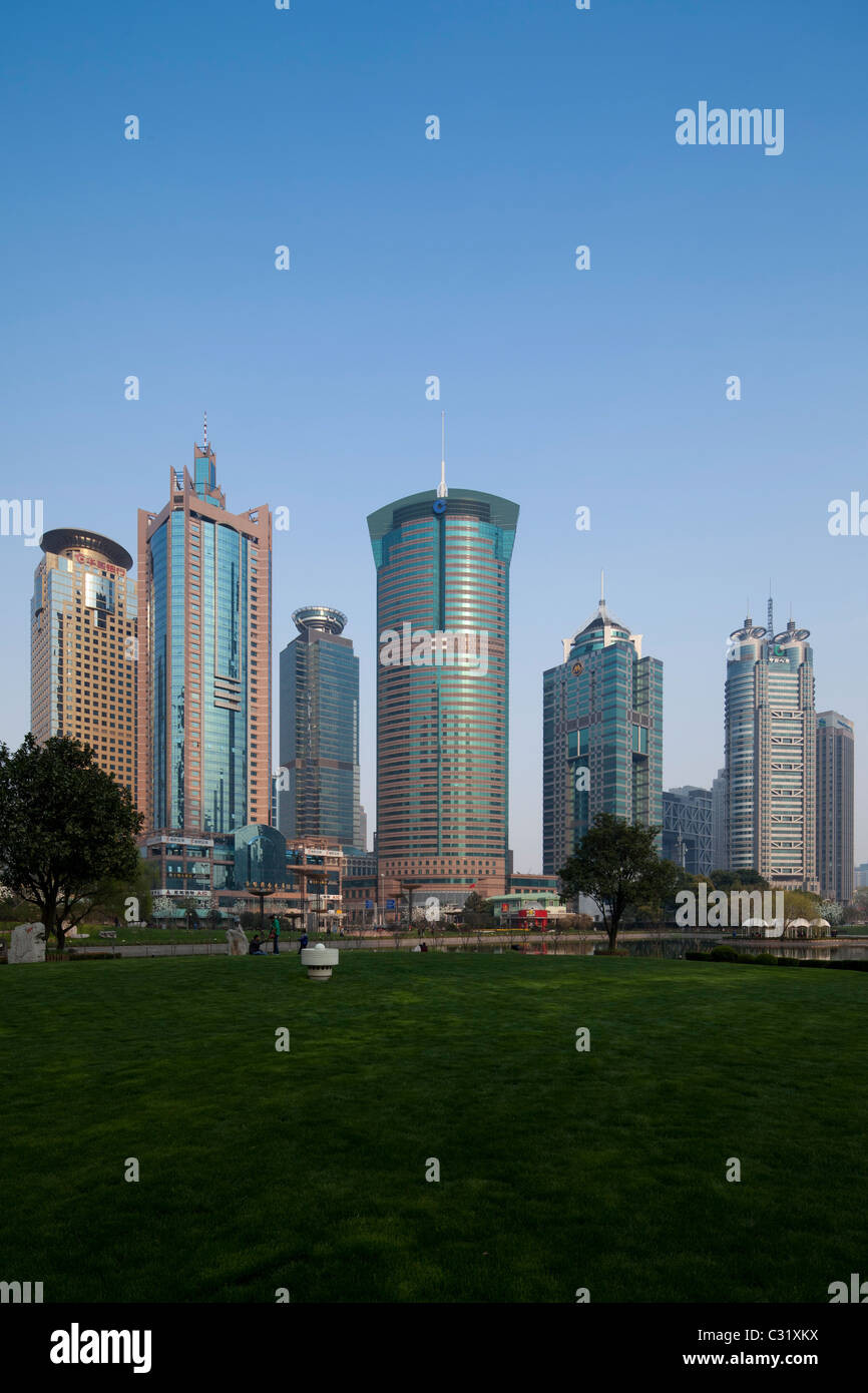 Torri di uffici nel quartiere finanziario di Pudong da attraverso le acque del lago nella Lujiazui centrale di spazio verde, Shanghai. Foto Stock