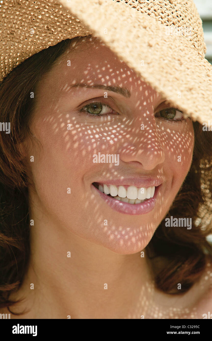 Donna che indossa un cappello per il sole con le ombre sul viso Foto stock  - Alamy