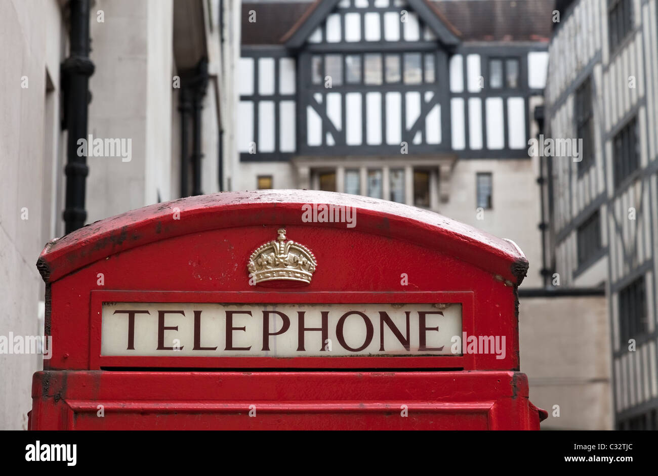 Classica Icona britannica, il K6 Telefono rosso scatola con un graticcio in stile Tudor edificio in background. Foto Stock