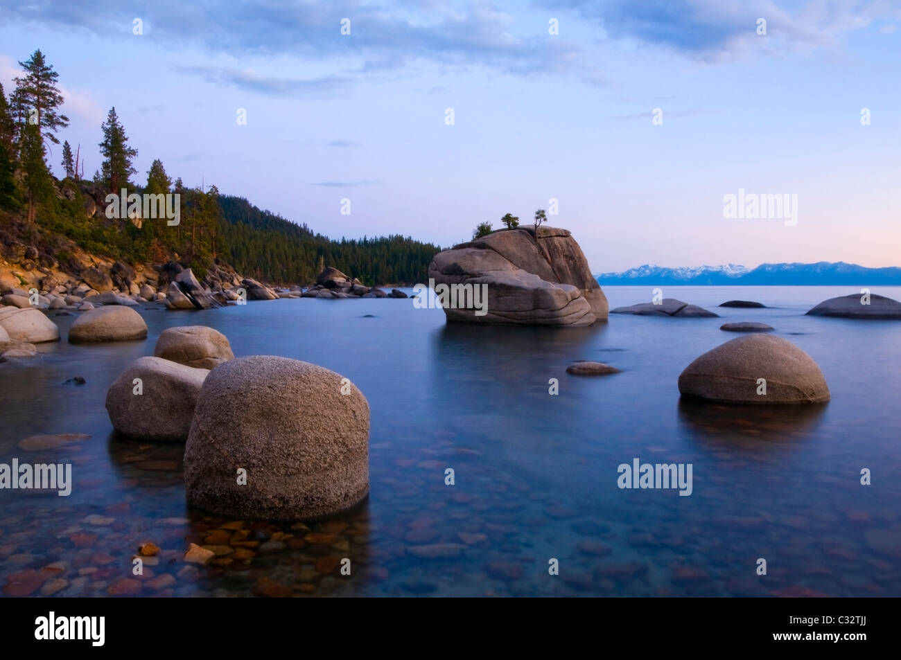 La luce della sera illumina i massi di granito e calme acque del lago Tahoe in estate, NV. Foto Stock