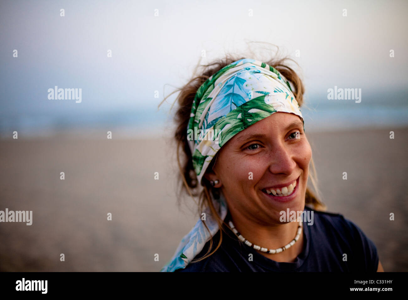 Una donna che indossa una bandana attorno alla sua testa sorrisi mentre  presso la spiaggia di Oxnard in California Foto stock - Alamy