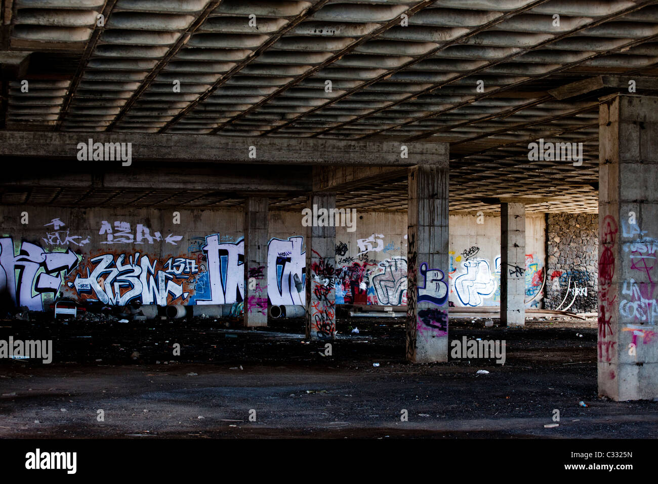 Un buio spazio urbano deturpato da graffiti e spazzatura Foto Stock