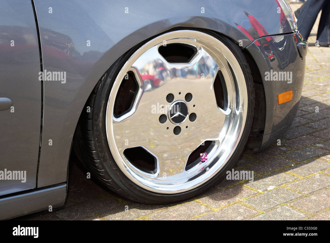 Chrome mercedes ruota su una sospensione abbassata la Volkswagen Golf con conseguenti danni ala in corrispondenza di una vettura modificata mostra nel Regno Unito Foto Stock