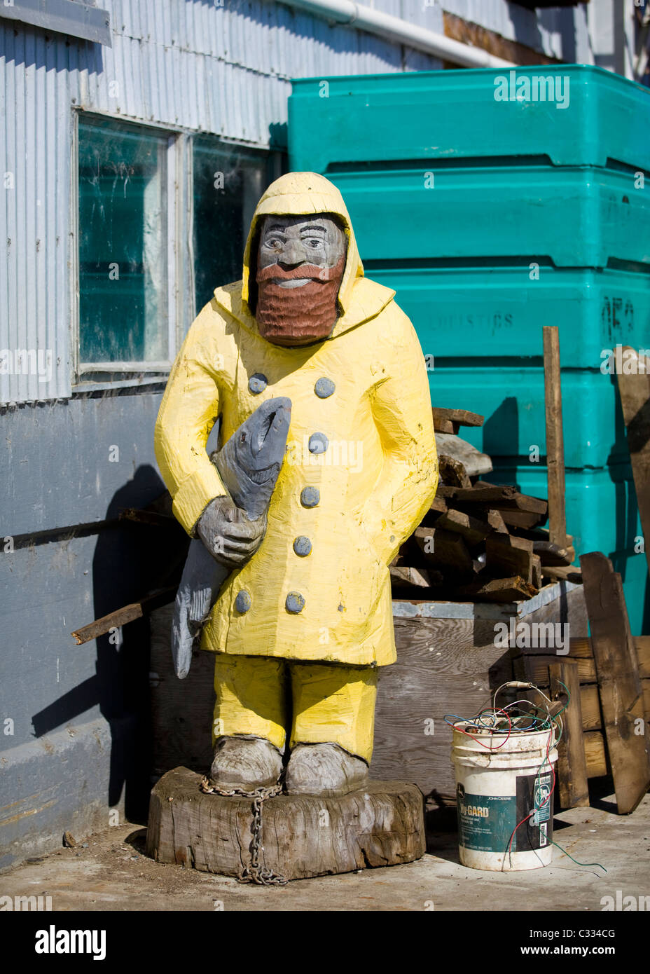 Statua in legno del pescatore tenendo il pesce e indossa una giacca impermeabile giallo - Monterey, California, Stati Uniti d'America Foto Stock
