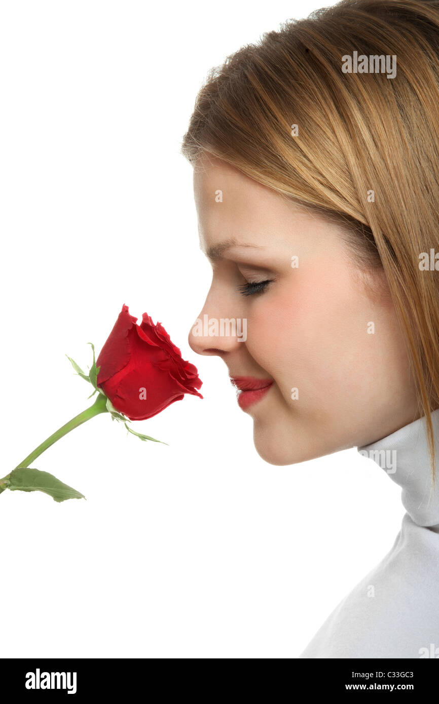Giovane bella donna odorare una rosa rossa Foto Stock