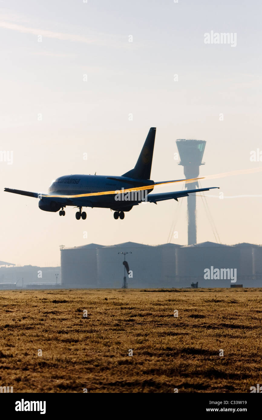 Aereo commerciale in atterraggio a Londra Heathrow con le scie di condensazione formando al di sopra di dette alette. Foto Stock